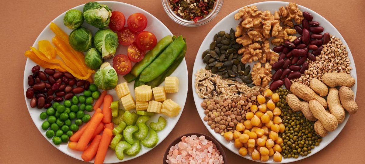 Vibrant display of assorted vegetables, legumes, nuts, and seeds on plates, perfect for healthy eating images.